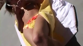 Hot blonde model shows off her body in a bikini in public