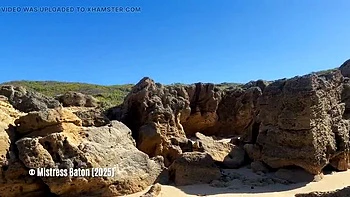 Blonde Mistress Canes Slave in Bikini on Beach